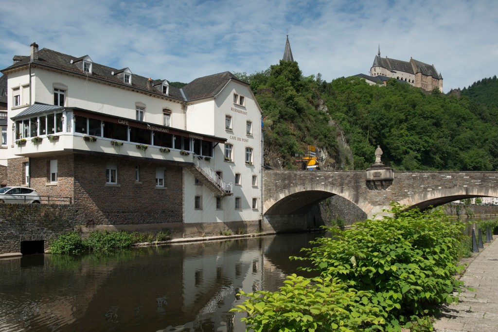 Panoramic view of Café-Restaurant Du Pont and the historic Vianden Castle on the mountain, taken from across the river Our by Dutch photographer Marcel de Hoog.
