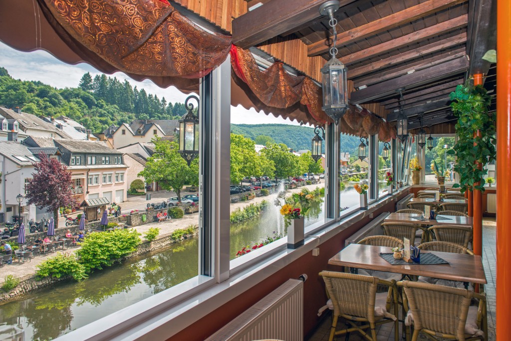 View from the Du Pont restaurant in Vianden overlooking the river Our and outdoor cafes on the other side of the water, photo by Marcel de Hoog.