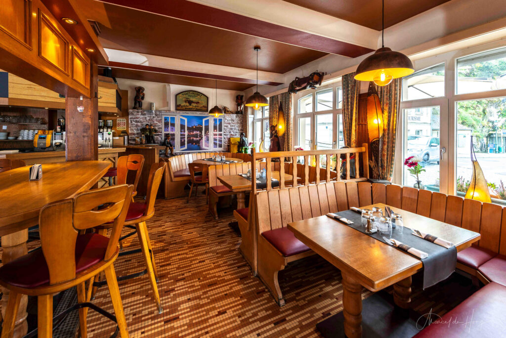 Tables by the window in the café section of Du Pont in Vianden, offering a bright and welcoming atmosphere. Photo by Marcel de Hoog.